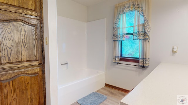 bathroom featuring hardwood / wood-style flooring and plus walk in shower