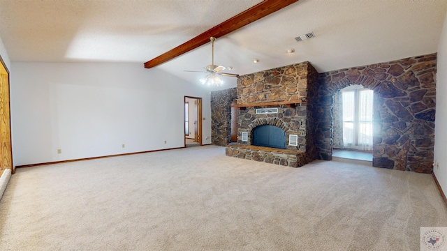 unfurnished living room featuring a textured ceiling, carpet floors, a fireplace, lofted ceiling with beams, and ceiling fan