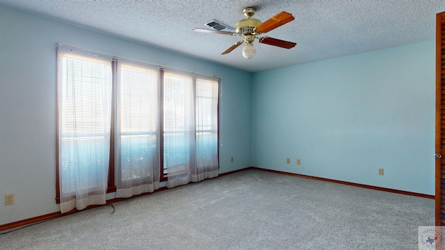 carpeted spare room with ceiling fan and a textured ceiling