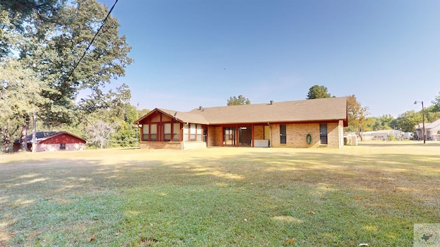 view of front of house with a front yard and a sunroom