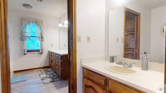 bathroom featuring vanity, hardwood / wood-style floors, and a textured ceiling