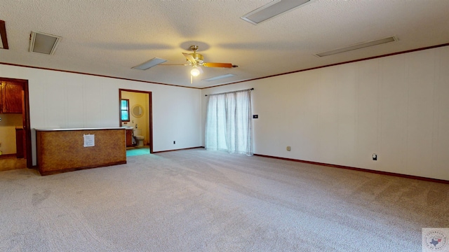 unfurnished room featuring light carpet, a textured ceiling, ceiling fan, and crown molding