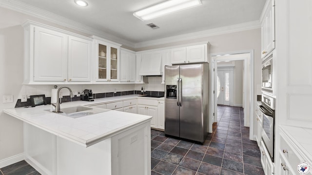 5906 Winchester Dr, Texarkana, TX 75503 - kitchen with stainless steel appliances, a peninsula, white cabinetry, glass insert cabinets, and crown molding
