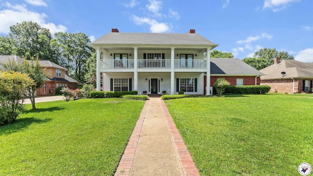 5906 Winchester Dr, Texarkana, TX 75503 - greek revival house featuring covered porch, a balcony, a front lawn, and a chimney