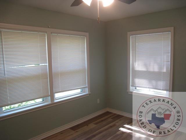 unfurnished room with ceiling fan and dark hardwood / wood-style floors