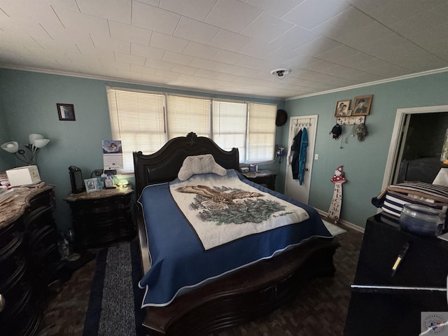 bedroom with dark carpet and crown molding