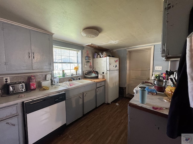 kitchen featuring sink, dark hardwood / wood-style floors, dishwasher, and white fridge