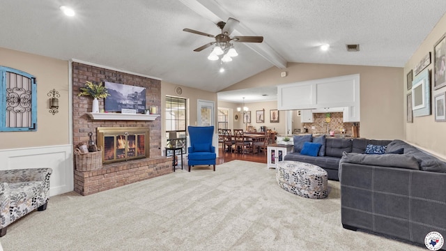 509 Brown Dr, Wake Village, TX 75501 - carpeted living area featuring a fireplace, a ceiling fan, a textured ceiling, and a wainscoted wall