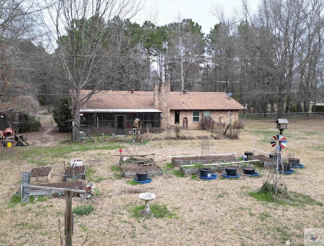 rear view of house featuring fence and a garden