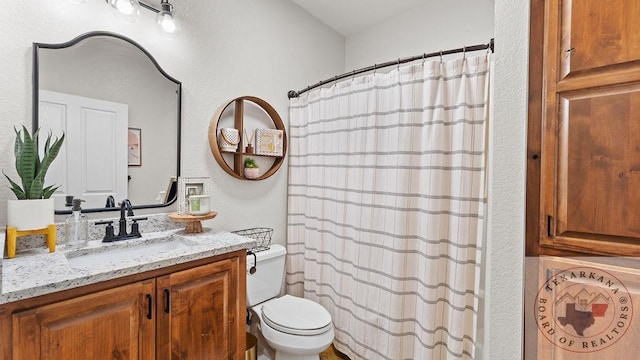 bathroom featuring toilet, a shower with shower curtain, and vanity