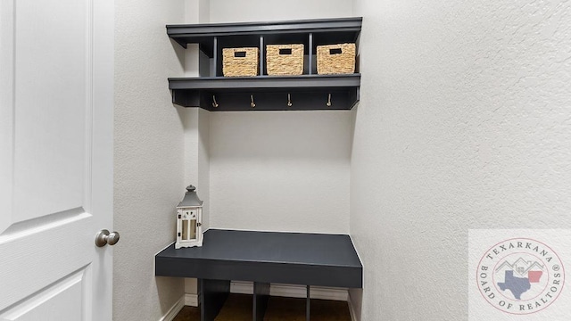 mudroom featuring a textured wall and baseboards