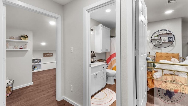 bathroom featuring visible vents, toilet, vanity, wood finished floors, and baseboards