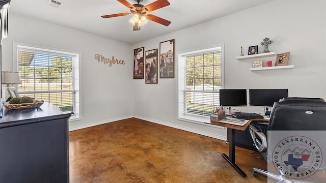 office space featuring baseboards, concrete floors, visible vents, and a ceiling fan