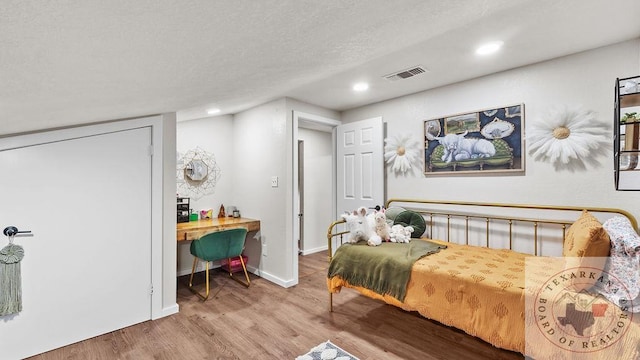 bedroom featuring baseboards, visible vents, wood finished floors, a textured ceiling, and recessed lighting