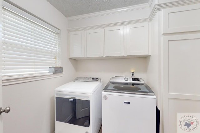 laundry area featuring cabinets, a textured ceiling, washing machine and dryer, and ornamental molding