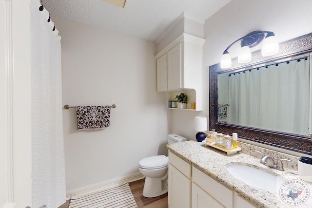 bathroom featuring wood-type flooring, toilet, a textured ceiling, and vanity