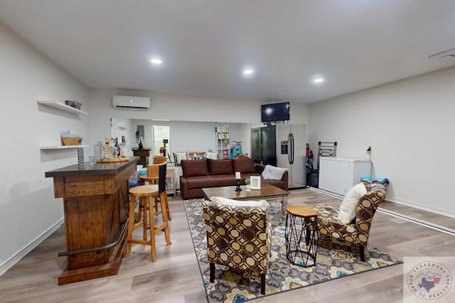 living room featuring an AC wall unit, bar area, and light wood-type flooring