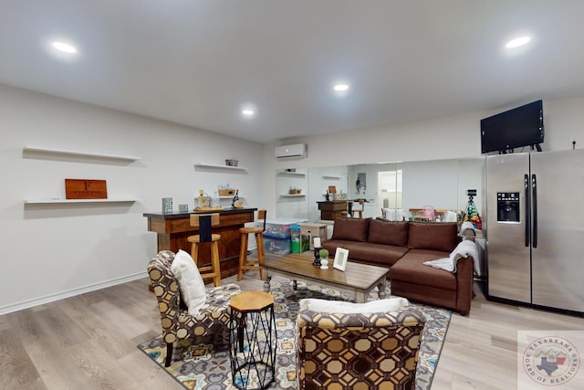 living room featuring an AC wall unit and light hardwood / wood-style floors