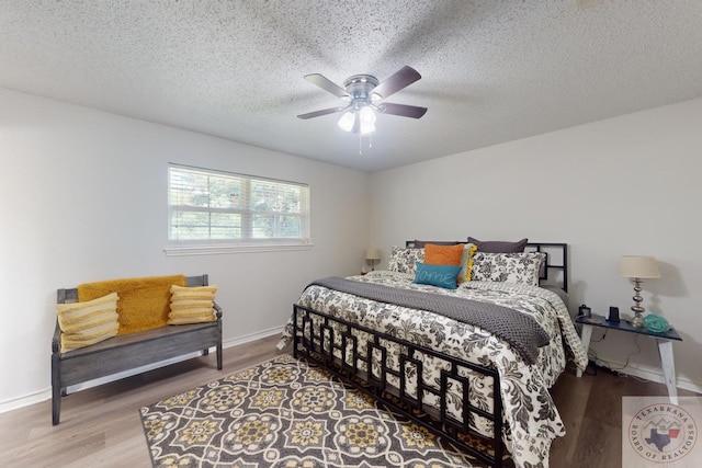 bedroom featuring ceiling fan, a textured ceiling, and wood-type flooring