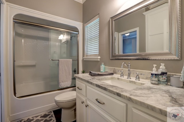 full bathroom featuring vanity, toilet, and combined bath / shower with glass door