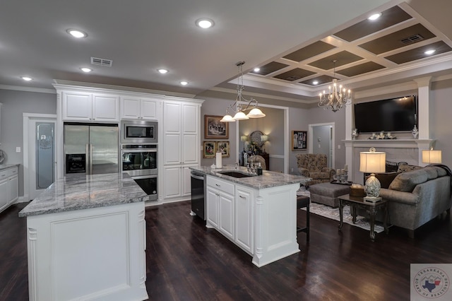 kitchen featuring a center island with sink, white cabinets, light stone countertops, and appliances with stainless steel finishes