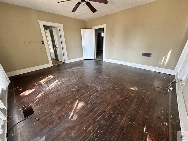 unfurnished room featuring ceiling fan, dark wood-type flooring, and a textured ceiling