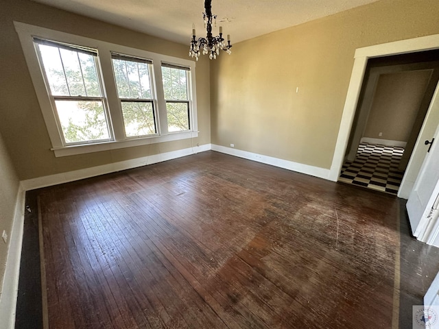 unfurnished dining area with dark wood-type flooring and a chandelier