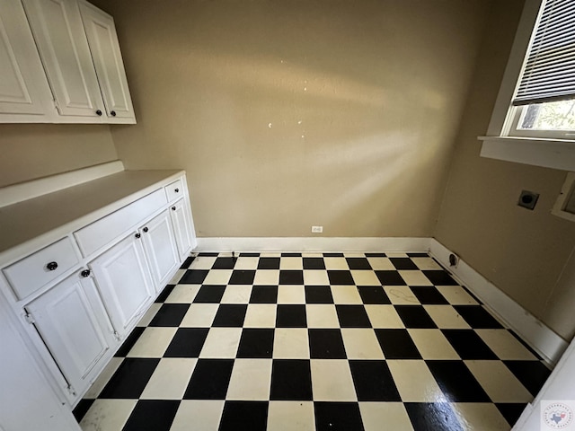 laundry room with electric dryer hookup and cabinets