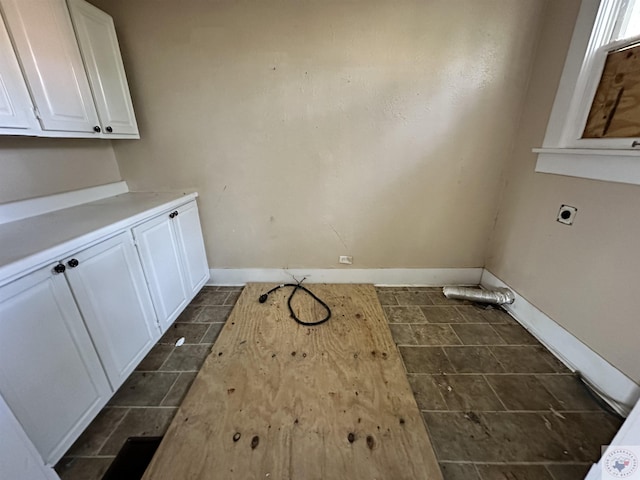 clothes washing area with electric dryer hookup and cabinets