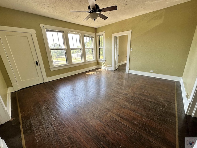 spare room with ceiling fan, a textured ceiling, and dark hardwood / wood-style floors