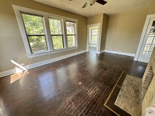 empty room featuring a textured ceiling, dark hardwood / wood-style floors, and ceiling fan