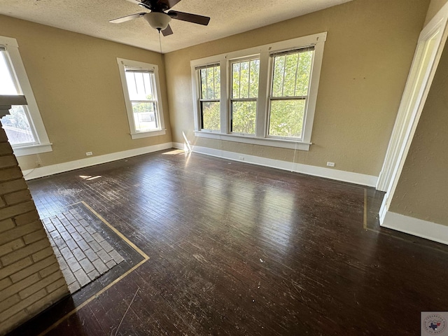 unfurnished room with a textured ceiling, dark hardwood / wood-style floors, and ceiling fan