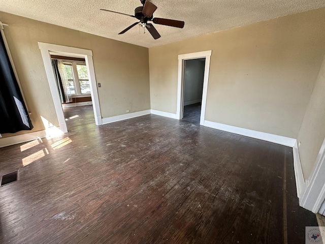 unfurnished living room featuring dark wood-type flooring and a textured ceiling