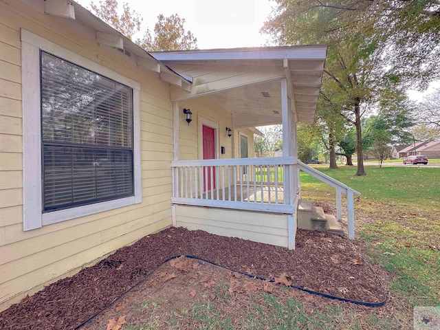 exterior space with covered porch and a yard