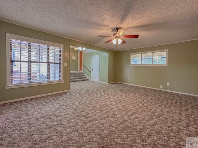 empty room featuring a wealth of natural light, ornamental molding, and carpet floors