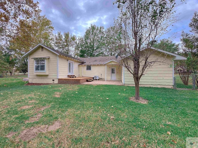 rear view of property with a lawn and a deck