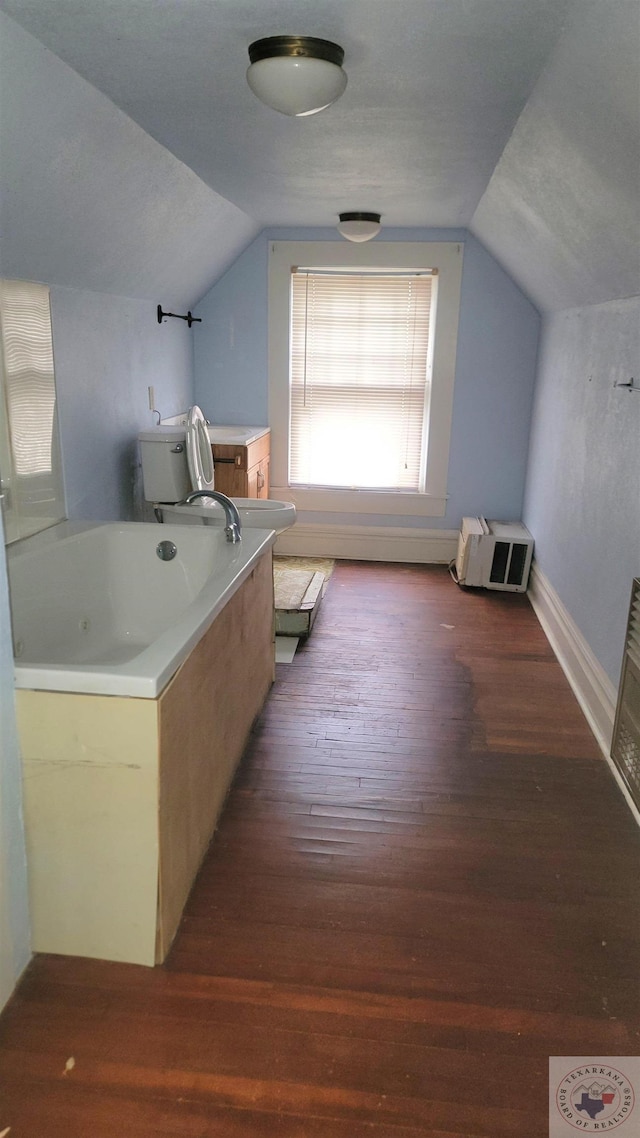 bathroom with a tub, hardwood / wood-style floors, and lofted ceiling