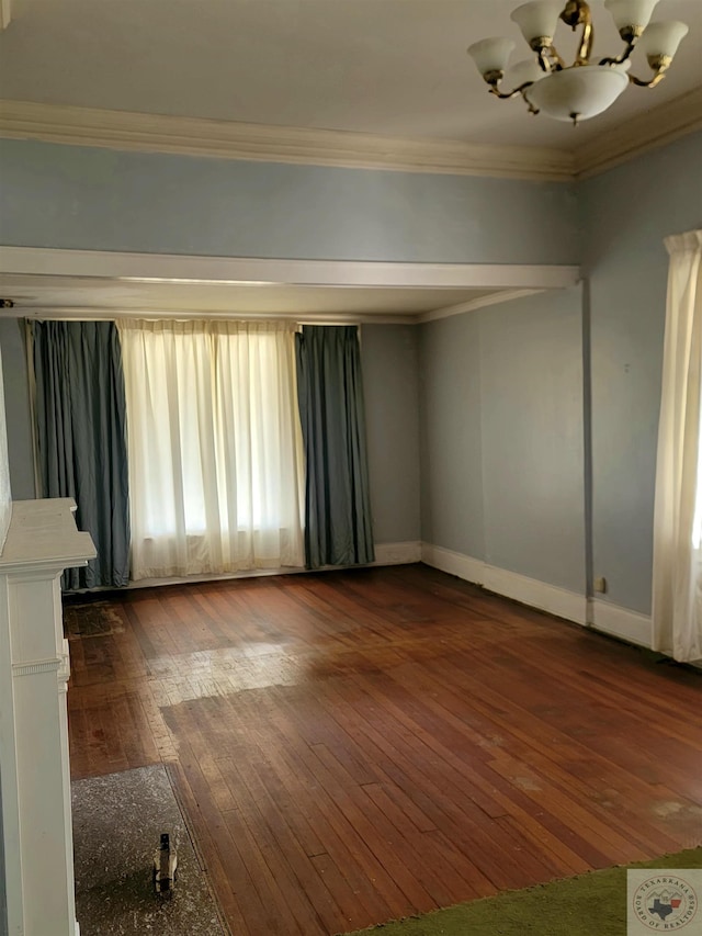 unfurnished room with an inviting chandelier, plenty of natural light, dark hardwood / wood-style flooring, and crown molding