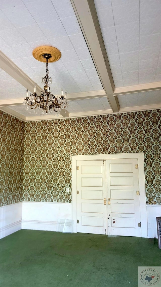 interior space with beamed ceiling, carpet flooring, and crown molding