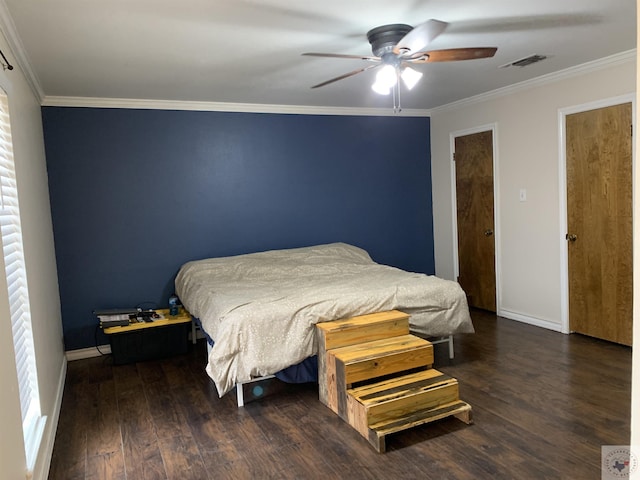 bedroom featuring baseboards, wood finished floors, visible vents, and ornamental molding