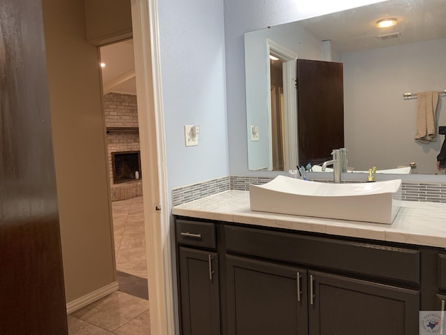 bathroom featuring vanity, tile patterned floors, a fireplace, and visible vents