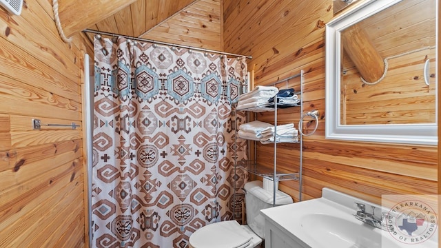 bathroom featuring toilet, curtained shower, wood walls, and vanity