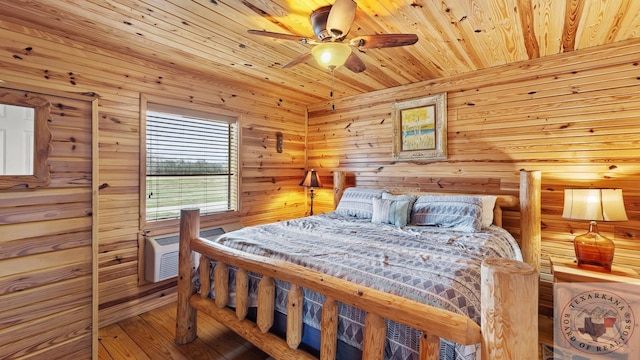 bedroom featuring a wall mounted AC, wood finished floors, wood ceiling, and a ceiling fan