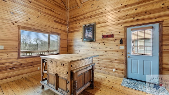 doorway with wood walls and light wood finished floors