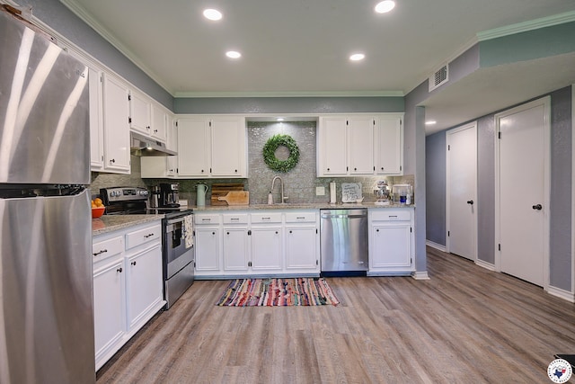 3009 Crestridge Dr, Texarkana, TX 75503 - kitchen with ornamental molding, under cabinet range hood, white cabinetry, and appliances with stainless steel finishes