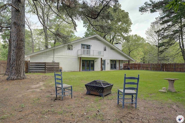 3009 Crestridge Dr, Texarkana, TX 75503 - back of house with a lawn, an outdoor fire pit, french doors, a fenced backyard, and brick siding