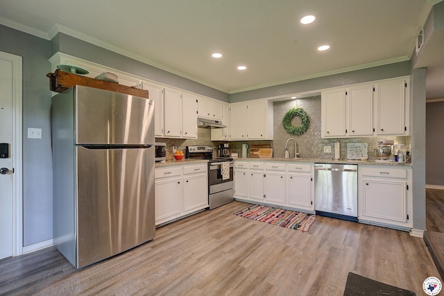3009 Crestridge Dr, Texarkana, TX 75503 - kitchen with white cabinets, light wood-style flooring, under cabinet range hood, and appliances with stainless steel finishes