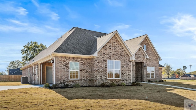 view of front of property with a front yard, central air condition unit, and a garage