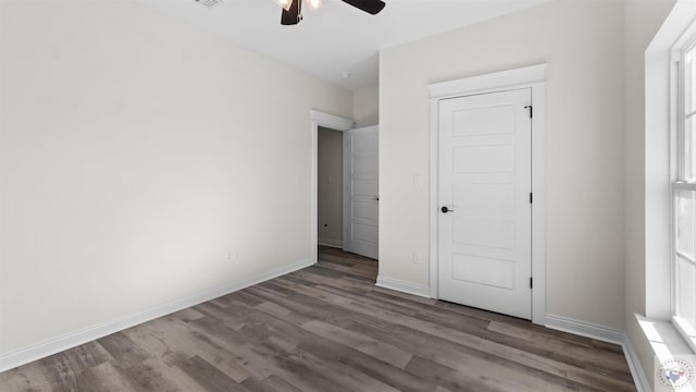 unfurnished bedroom featuring ceiling fan and dark hardwood / wood-style flooring