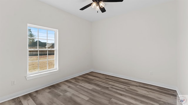 empty room featuring a healthy amount of sunlight, hardwood / wood-style flooring, and ceiling fan